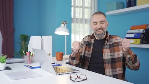 Man Celebrating Success While Working at Computer
