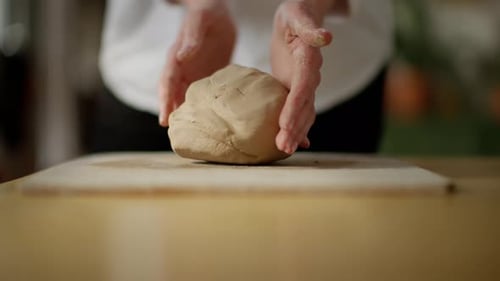 Chef Kneading Dough on Floured Surface