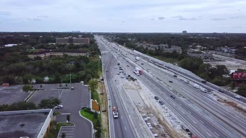 Vue aérienne par Drone se déplaçant lentement vers l'avant d'une autoroute très fréquentée montrant la circulation de véhicules.