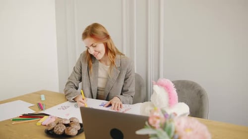 Young Woman Drawing Pictures at Table
