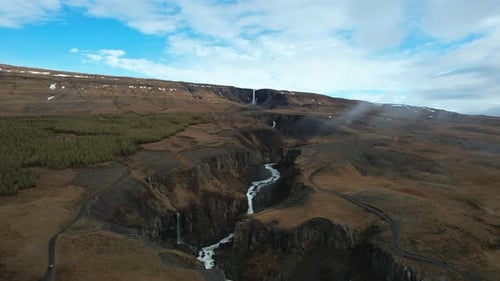 Flying Over a Waterfall in the Icelandic Canyon