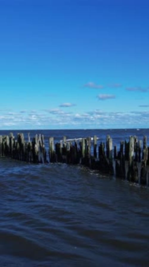 A wooden structure in the ocean with waves coming in