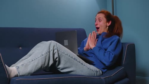 Woman Video Chatting on Laptop While Relaxing on Couch