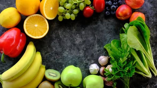 Colorful Fruits and Vegetables Arranged on Dark Surface