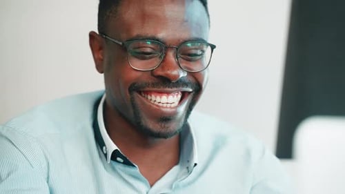 Smiling Young Adult With Glasses Working at Desk