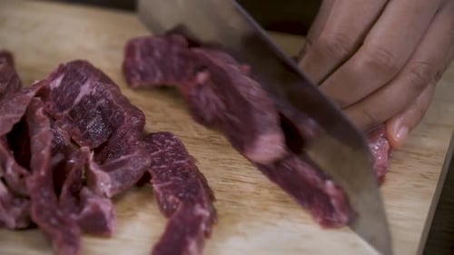 Meat Slices Being Cut On Cutting Board