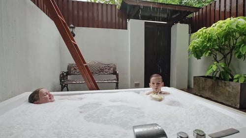 Woman and Child Relaxing in Tropical Jacuzzi