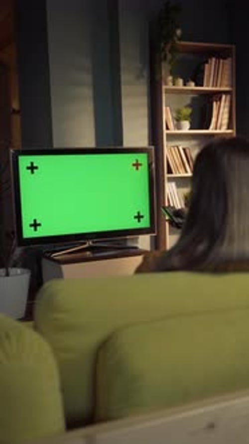Woman Watches Green Screen TV at Home at Night