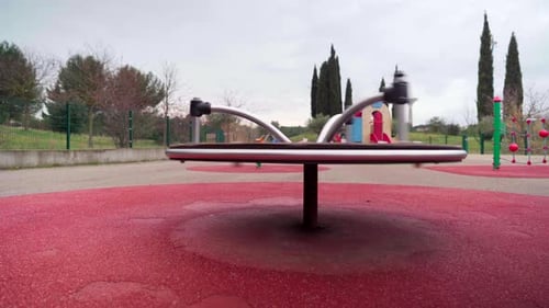 Empty playground during Covid-19 coronavirus pandemic lockdown, carousel spinning on its own