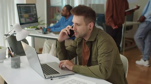 Project Manager Communicating with Client on Smartphone at Office