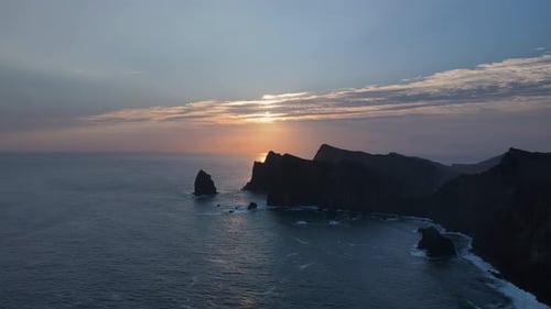 Aerial drone footage showcasing majestic mountain summits as they meet the tranquil ocean horizon du