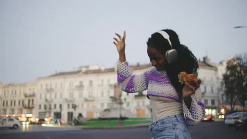 Joyful Moments in the City A Young Woman is Found Fully Enjoying Her Time with Music While Indulging