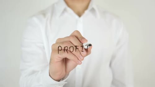 Person Writes the Word Profit on Clear Surface