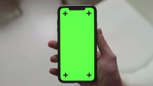 swinging a smartphone in front of the camera with green screen display and tracking markers, static