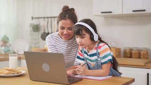 Woman Helps Child Learning Online at Home