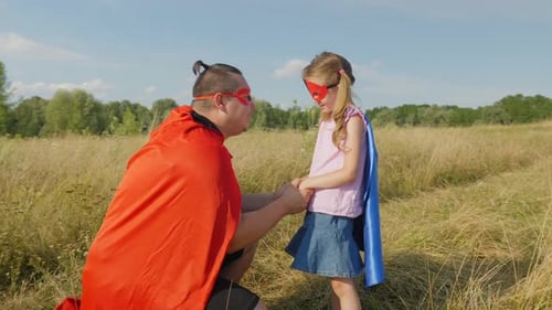 Dad and Daughter Playing Superheroes in Rural Field
