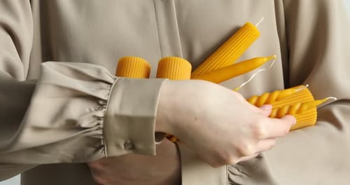 Woman with many different beeswax candles, closeup