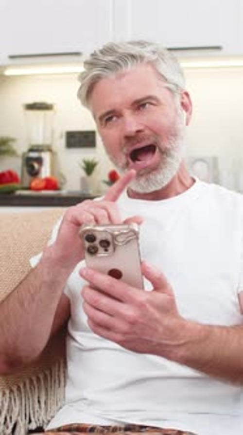 Un hombre de mediana edad practica frases lingüísticas con auriculares en la aplicación de su teléfono inteligente, repite y se siente orgulloso