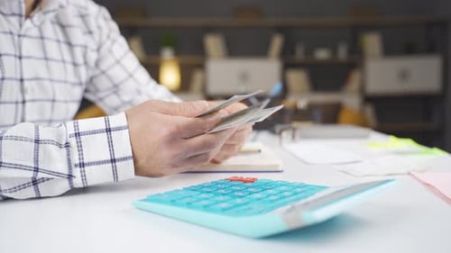 Hands Count Cash at White Desk in Office
