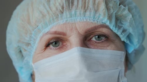 Close Up of Woman Wearing Surgical Mask and Cap
