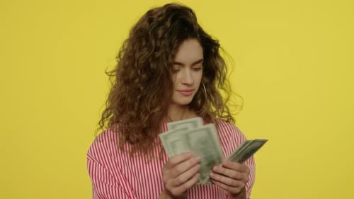 Woman Counting Money on Yellow Background