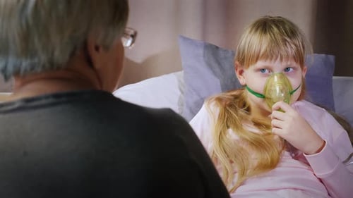 Une infirmière âgée s'occupe d'un enfant inhalé à la maison