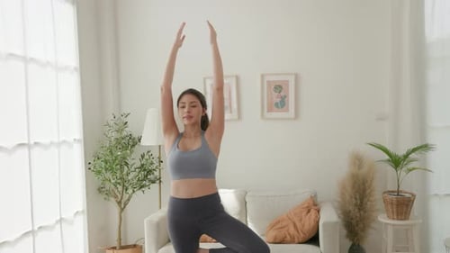 Young Woman Doing Yoga in Bright Living Room