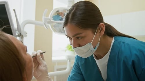 Zahnärztin führt Untersuchung einer Patientin durch