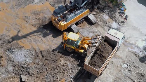 Aerial View of Excavator Loading Dirt into Truck