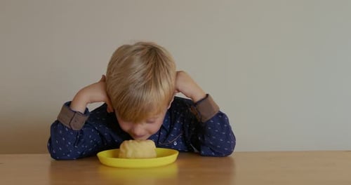 Smiling Boy with Blond Hair at Table