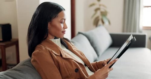 Stylish Woman Using Tablet on Couch Indoors