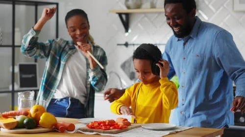 Happy Family Cooking and Dancing in Kitchen at Home
