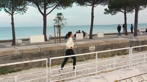Aerial Video of Caucasian Woman Running Waterfront Public Park