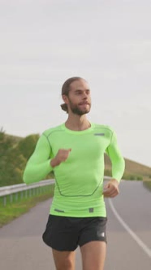 Confident Male Runner Jogging on the Empty Road in Cloudy Morning Athletic Active Young Bearded