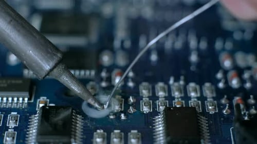 Soldering Iron Connects Component on Circuit Board