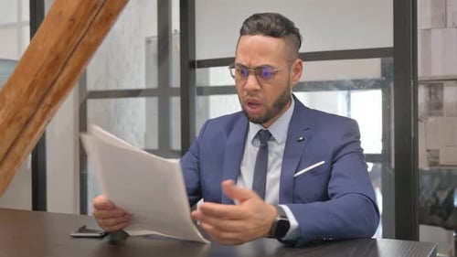 Young Adult Looking at Documents in an Office