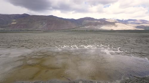 Barren Cracked Earth with Distant Mountains