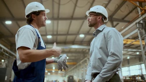 Engineer and Industrial Worker Shaking Hands and Talking in Factory