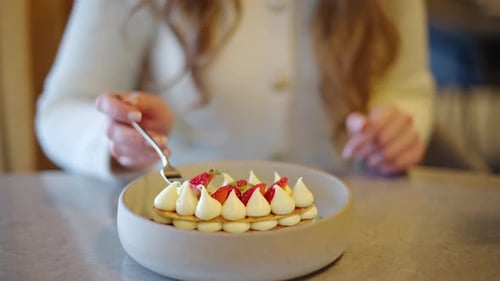 Dessert with Cream and Strawberries Being Eaten