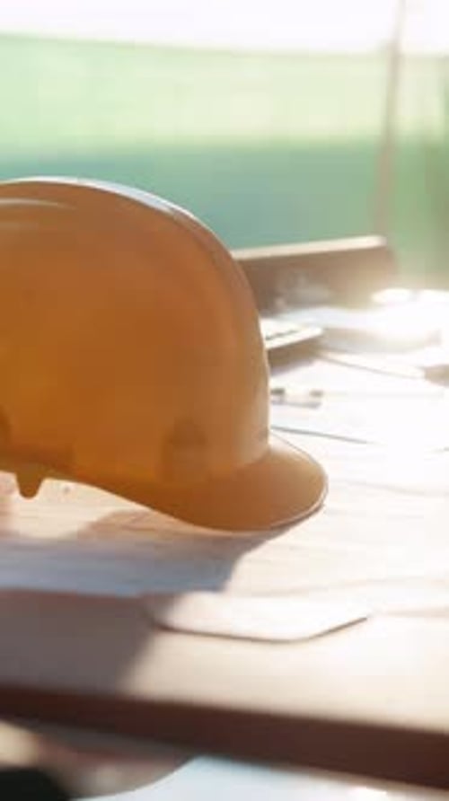 Construction, hardhat and sunlight with floor plan on desk at building site for property