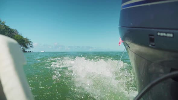 Rear view of a speed boat showing the wake created by the outboard ...