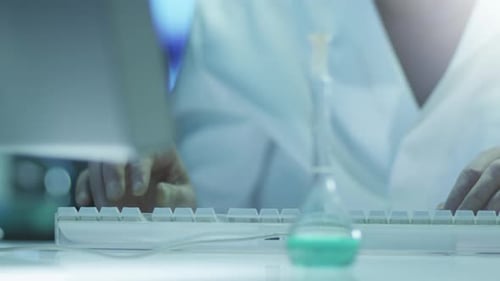 Scientist is Working on Computer in Laboratory. Close-up.