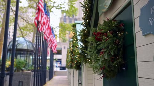 Christmas wreaths decorating the buildings exteriors. A row of American flags at blurred backdrop.