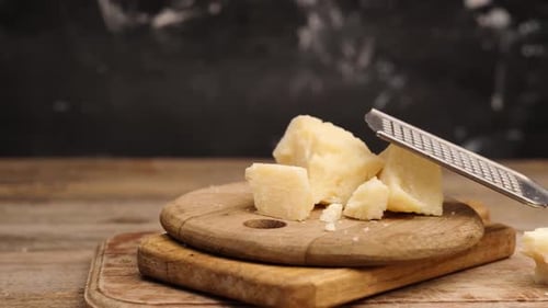 Morceaux de parmesan posés à côté d'une râpe