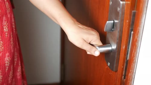 Hand Turns Door Handle to Open Door