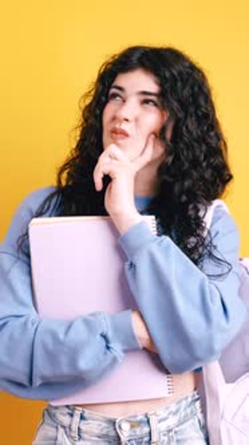 Thoughtful Young Woman Holding Notebook With Idea