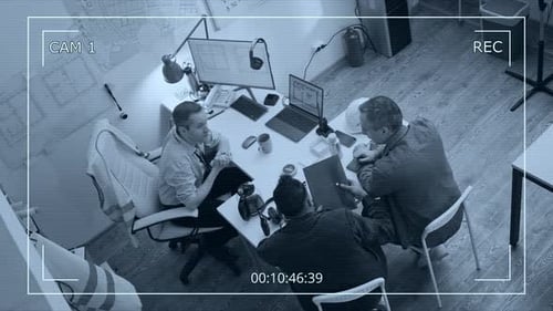 CCTV of Engineers Reviewing Blueprints and Papers at Desk in Construction Office