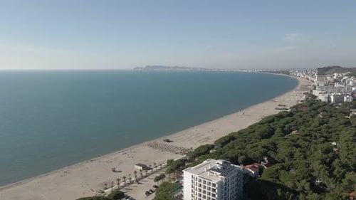 Adriatic beach aerial descends over tourist hotels in Golem, Albania