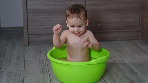 Delightful Baby Bath Time in Green Basin