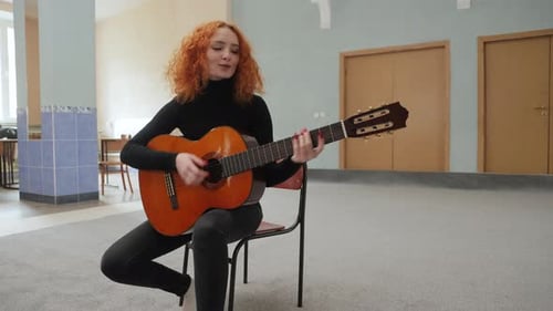 Young Woman Plays Guitar Indoors
